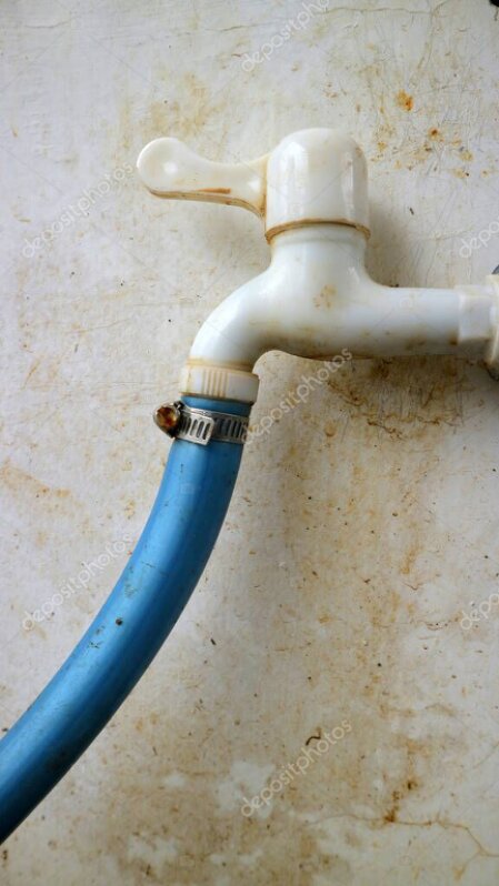 Elementy infrastruktury ogrodu: kran z wodą, świetlica i pojemniki na odpady.